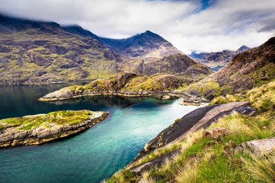 Scenic view of lake by mountains against sky