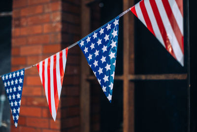 American flag decoration near red brick wall.