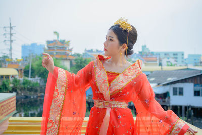 Young woman in traditional clothing standing at temple