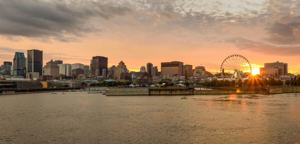 Scenic view of illuminated buildings against sky during sunset