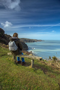 Woman looking at sea against sky