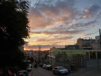 Cars on road against cloudy sky