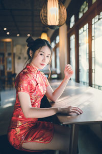 Portrait of young woman sitting at table