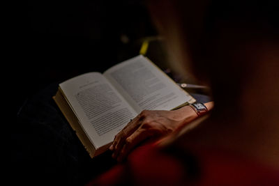 Midsection of person reading book