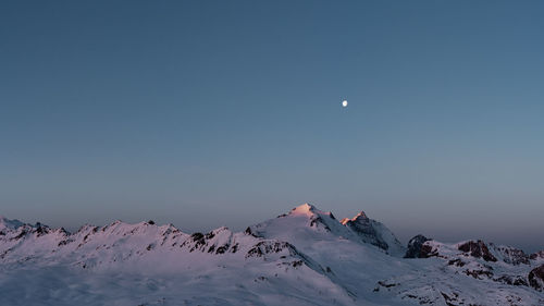 Scenic view of snowcapped mountains against clear blue sky