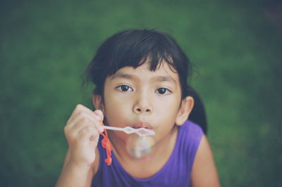 High angle portrait of cute girl blowing bubble