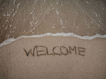 High angle view of text on sand