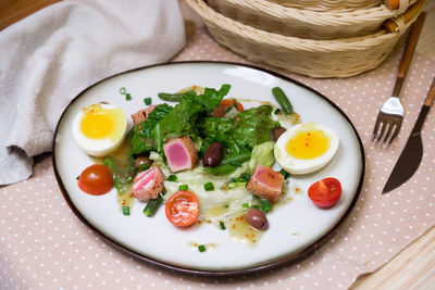 Nicoise salad with fresh vegetables, boiled eggs, tuna, and olive oil. dressed with lemon juice.