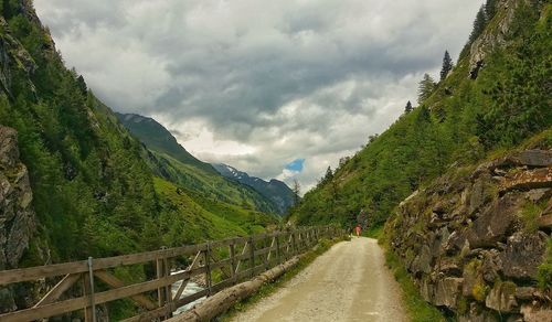 Road amidst green landscape against sky