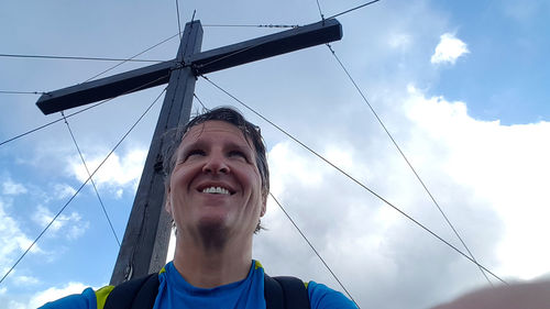 Low angle view of smiling woman against sky