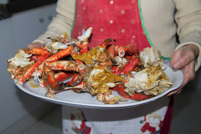 Woman holding tray of cooked crab, lunch or christmas dinner