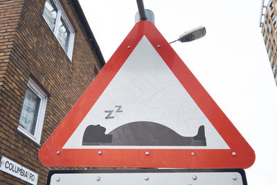 Close-up of road sign against sky