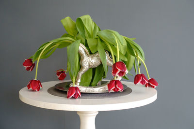 Close-up of red flowers on table against white background