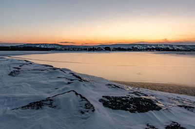 Scenic view of frozen sea against sky during sunset