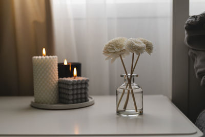 Close-up of illuminated candles on table