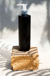 Close-up of beer bottle against wall