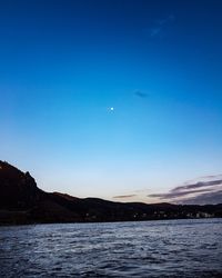 Scenic view of sea against clear blue sky at night