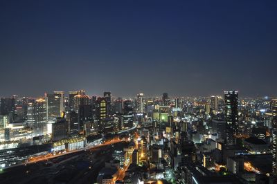 Illuminated cityscape against sky at night