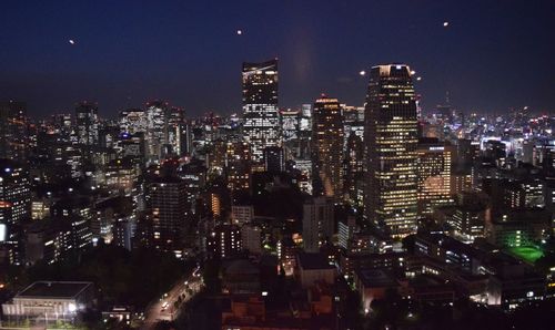 Illuminated cityscape against sky at night