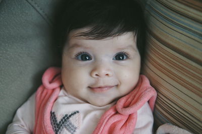 High angle portrait of cute baby girl lying on bed