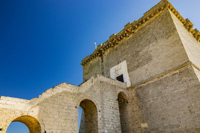 Low angle view of old building against blue sky