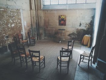 Empty chairs and table against wall at home