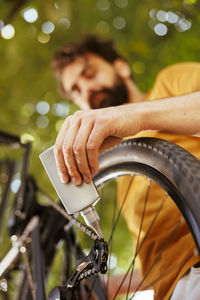 Cropped hand of man holding bicycle