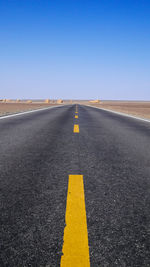 Road sign against clear blue sky