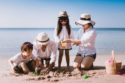 People at beach against sky