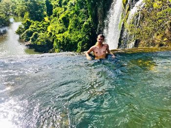 Full length of shirtless man in river