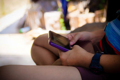 Midsection of woman holding mobile phone