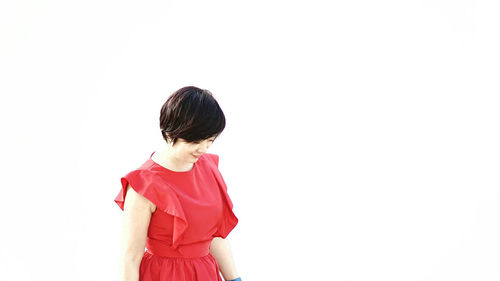 Woman in red dress standing against white background