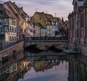 Canal in city against sky