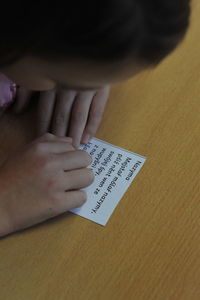 High angle view of woman with text on table