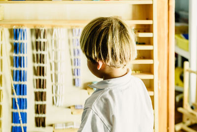 Side view of boy standing at home