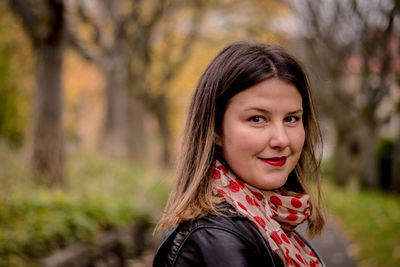 Portrait of smiling woman against trees