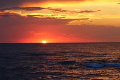 Scenic view of sea against orange sky