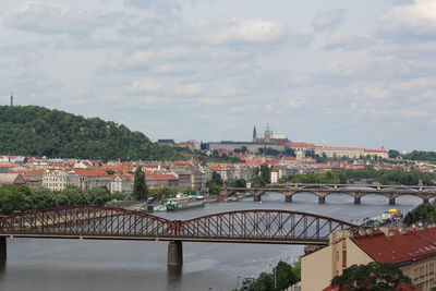 Bridge over river in town against sky