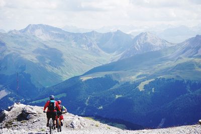 Rear view of man and snowcapped mountains against sky