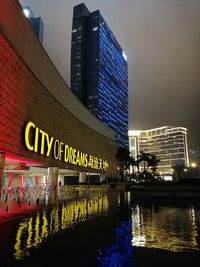Reflection of illuminated modern buildings in city at night