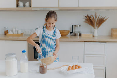 Girl preparing food on kitchen island at home