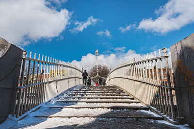 Rear view of people on staircase against sky