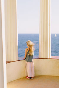 Rear view of young woman looking at sea