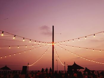 Low angle view of illuminated lights against sky at dusk