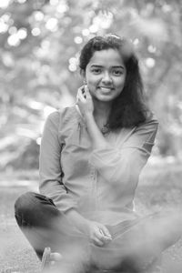 Portrait of smiling beautiful young woman sitting outdoors