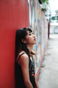 Woman standing against graffiti wall