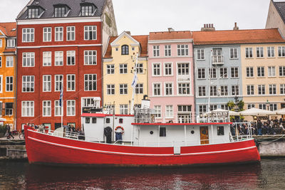 Boats moored on river against buildings in city