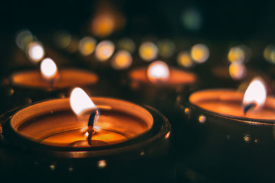 Close-up of illuminated tea lights in darkroom