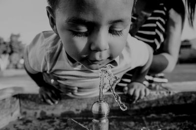 Close-up of baby at drinking fountain