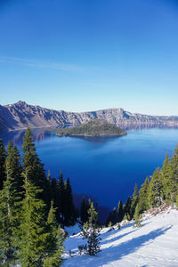 Scenic view of lake and snowcapped mountains against blue sky